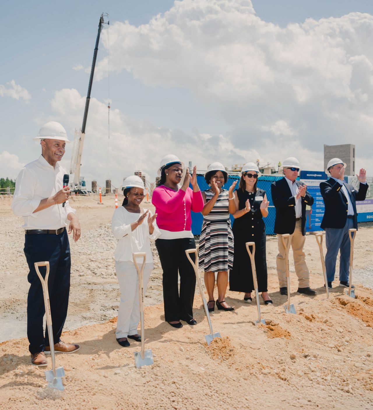 leaders stand in front of ground breaking shovels